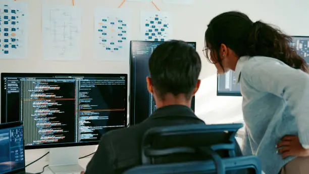 Web developer bekerja dengan laptop dan kode pada layar